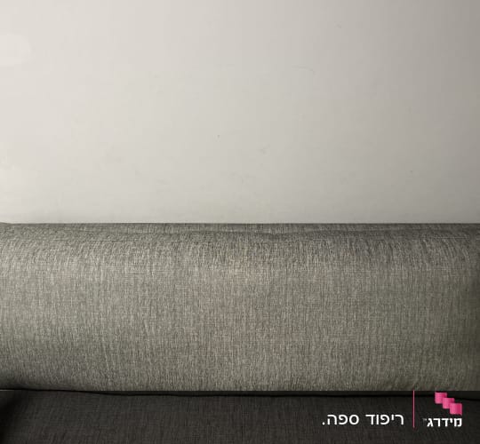 כרית גב מרופדת על ספה אפורה